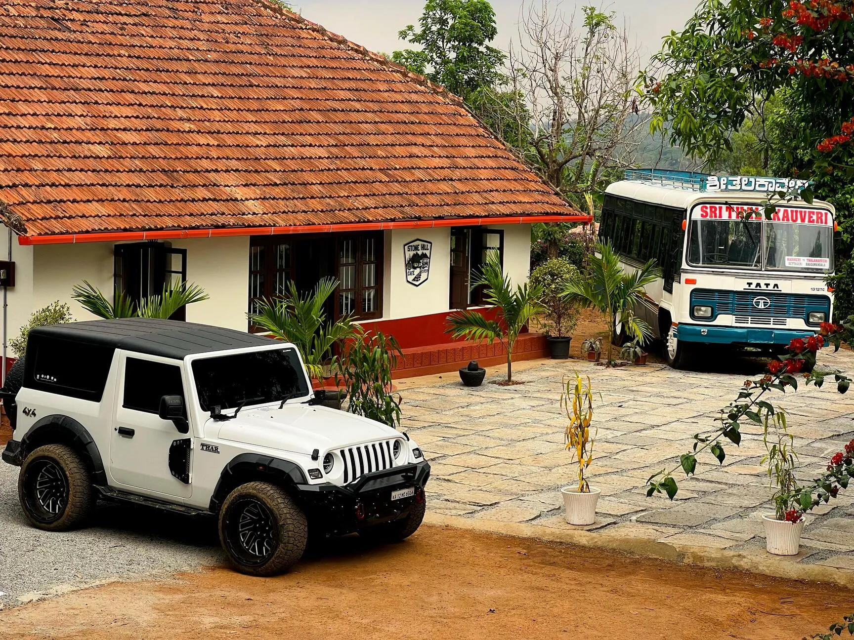 The building with its long tiled roof, a vehicle parked on the courtyard in front.